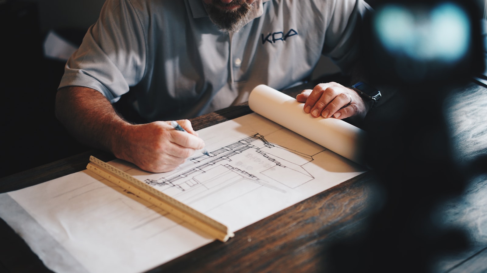 Commercial construction project manager reviewing subcontractor invoices and contract documents at a job site